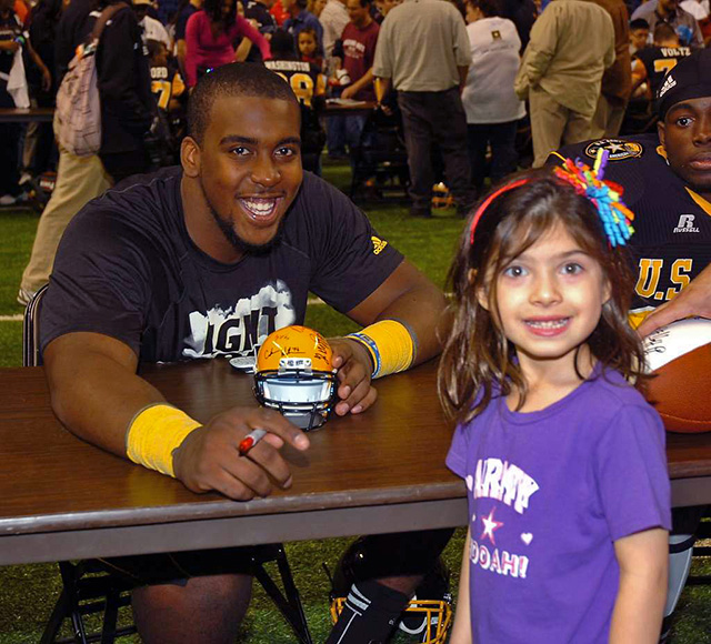 a fan collects a signature from a US Army football player